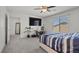 Cozy bedroom features a large window, ceiling fan, a workstation and neutral carpeting at 9054 Tangerine Tree Ct, Las Vegas, NV 89113