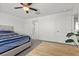 Bright bedroom features a ceiling fan, gray carpet and an adjacent bathroom for added convenience at 9054 Tangerine Tree Ct, Las Vegas, NV 89113
