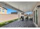 A covered patio has tiled flooring, outdoor furniture and a grill great for entertaining at 9054 Tangerine Tree Ct, Las Vegas, NV 89113