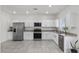 Contemporary kitchen with stainless steel appliances, granite countertops, and white cabinetry at 9054 Tangerine Tree Ct, Las Vegas, NV 89113