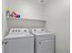 Bright laundry area with appliances and storage shelf, offering convenience and functionality at 9054 Tangerine Tree Ct, Las Vegas, NV 89113