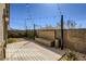 Modern backyard with wooden deck, built-in bench, manicured shrubs, and ambient string lights at 9351 Aria Ridge Ave, Las Vegas, NV 89143