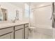 Bright bathroom with white tiled shower-tub combination, modern vanity, and tiled floors at 9351 Aria Ridge Ave, Las Vegas, NV 89143