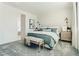 Cozy bedroom with patterned accent wall, bench, and comfortable carpet at 9351 Aria Ridge Ave, Las Vegas, NV 89143