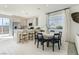 Open-concept kitchen with stainless steel appliances and a breakfast bar island leading to a dining space at 9351 Aria Ridge Ave, Las Vegas, NV 89143