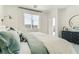 Cozy bedroom showcasing soft, neutral tones, a large window, and a modern dresser at 9351 Aria Ridge Ave, Las Vegas, NV 89143