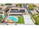 Aerial view of backyard oasis: pool with grotto, solar panels, sport court, and covered patio, ideal for outdoor living at 9410 Stone Castle Way, Las Vegas, NV 89123
