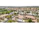 High-angle view of a community with neatly arranged homes, showcasing solar panels, pools, and green spaces at 9410 Stone Castle Way, Las Vegas, NV 89123
