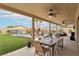 Covered patio with a dining table, ceiling fans, and a beautiful view of the pool and backyard at 9410 Stone Castle Way, Las Vegas, NV 89123