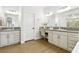 Bright bathroom featuring dual sinks, vanity, wood-look floors, and a neutral color palette at 9410 Stone Castle Way, Las Vegas, NV 89123