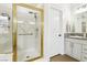 Bathroom featuring a glass shower with gold trim, neutral colored vanity, and wood-look floors at 9410 Stone Castle Way, Las Vegas, NV 89123