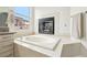 Bathroom featuring a soaking tub, fireplace, neutral colored vanity, and a window with a view at 9410 Stone Castle Way, Las Vegas, NV 89123