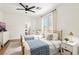 Bright bedroom with two beds, bathroom access, and natural light, creating a cozy and inviting space at 9410 Stone Castle Way, Las Vegas, NV 89123