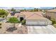 Inviting single-story home with a tile roof, three-car garage, and desert landscaping at 9410 Stone Castle Way, Las Vegas, NV 89123