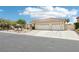 Charming single-story home featuring desert landscaping, a three-car garage, and a tile roof at 9410 Stone Castle Way, Las Vegas, NV 89123