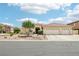 Lovely single-story home featuring desert landscaping, a three-car garage, and a tile roof on a sunny day at 9410 Stone Castle Way, Las Vegas, NV 89123