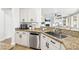 Bright kitchen featuring granite countertops, stainless steel appliances, and white cabinets at 9410 Stone Castle Way, Las Vegas, NV 89123