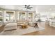 Bright, open living room with large windows, a modern sectional, and bar stool seating at the kitchen counter at 9410 Stone Castle Way, Las Vegas, NV 89123