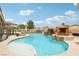 A stunning pool with a rock waterfall and spa surrounded by desert landscaping at 9410 Stone Castle Way, Las Vegas, NV 89123