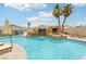 Stunning pool area with a rock waterfall, spa, and lush landscaping, creating a backyard oasis at 9410 Stone Castle Way, Las Vegas, NV 89123