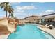 Resort-style pool area with rock waterfall, water slide, spa, and lush landscaping at 9410 Stone Castle Way, Las Vegas, NV 89123
