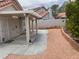 Backyard landscape featuring a stone wall, mature landscaping, and covered patio at 9600 Pacific View Dr, Las Vegas, NV 89117