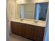Bathroom vanity with double sinks, wood cabinets, and large mirror at 9600 Pacific View Dr, Las Vegas, NV 89117