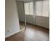 Bedroom featuring modern sliding mirrored closet door and laminate flooring at 9600 Pacific View Dr, Las Vegas, NV 89117