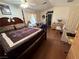 Spacious main bedroom with a four-poster bed, wood floors, and comfortable seating area at 977 Country Skies Ave, Las Vegas, NV 89123