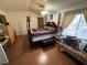 Bright main bedroom featuring a four-poster bed, wood floors, and a cozy seating area at 977 Country Skies Ave, Las Vegas, NV 89123