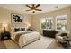 Staged bedroom features a comfortable bed, matching nightstands, and a cozy chair with backyard view at 10179 Emerald Sunset Ct, Las Vegas, NV 89148