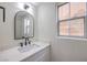 Stylish powder room features a sleek vanity with white countertop, black faucet, and modern mirror at 1097 Paradise Resort Dr, Henderson, NV 89002