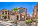 Charming two-story home features a desert landscape, a private two-car garage, and mature palm trees at 1097 Paradise Resort Dr, Henderson, NV 89002