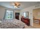 Comfortable bedroom with ceiling fan, dresser with TV and window with natural light at 1120 Tektite Ave, Henderson, NV 89011