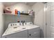 Efficient laundry room featuring a side by side washer and dryer with storage shelving above at 1120 Tektite Ave, Henderson, NV 89011