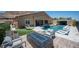 Relaxing backyard with a pool, spa, built-in fire pit, seating, and a well-manicured lawn, perfect for entertaining at 11248 Rebel Dome Ct, Las Vegas, NV 89141