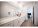 Elegant bathroom with double sinks, a large mirror, white cabinets, and modern fixtures with wood-look flooring at 11248 Rebel Dome Ct, Las Vegas, NV 89141