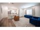 Open concept living space features modern furnishings, including a tufted blue sofa, and seamless flow to the kitchen at 11248 Rebel Dome Ct, Las Vegas, NV 89141