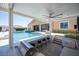 Spacious outdoor kitchen and patio area with ceiling fan, tile floors, and steps leading to the pool at 11248 Rebel Dome Ct, Las Vegas, NV 89141