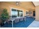 Spacious covered outdoor patio with modern furniture, a dining area, and a stylish blue patterned rug at 11248 Rebel Dome Ct, Las Vegas, NV 89141