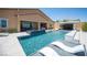 Inviting pool with submerged loungers, a water feature, and an outdoor entertainment area, perfect for relaxation at 11248 Rebel Dome Ct, Las Vegas, NV 89141