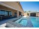 An inviting backyard pool and spa area, complete with a covered outdoor entertainment space and comfortable seating at 11248 Rebel Dome Ct, Las Vegas, NV 89141