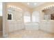 Bright bathroom features double sinks, arched window, and a tiled corner tub, offering a luxurious experience at 1311 Rolling Sunset St, Henderson, NV 89052