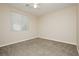 A simple bedroom with a ceiling fan, carpet flooring, and a window at 1311 Rolling Sunset St, Henderson, NV 89052