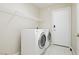 A bright laundry room with washer, dryer, white tiled floors, and wire shelving at 1311 Rolling Sunset St, Henderson, NV 89052