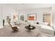 Bright, staged living room featuring modern furniture, large windows, and an open dining area at 1405 Wintergreen Dr, Las Vegas, NV 89128