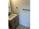 Bathroom with a wood vanity, white countertop, dark hardware, and wood-look flooring at 1512 Couples St, Las Vegas, NV 89128