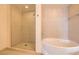 Bathroom with soaking tub, glass shower, and neutral tile throughout at 200 W Sahara Ave # 1102, Las Vegas, NV 89102