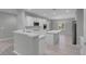 Open concept kitchen with white cabinets, modern appliances, an island, and hardwood floors at 2144 Mountain City St, Henderson, NV 89052