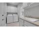 Well-lit laundry room equipped with appliances, ample cabinet space and a convenient sink at 2144 Mountain City St, Henderson, NV 89052